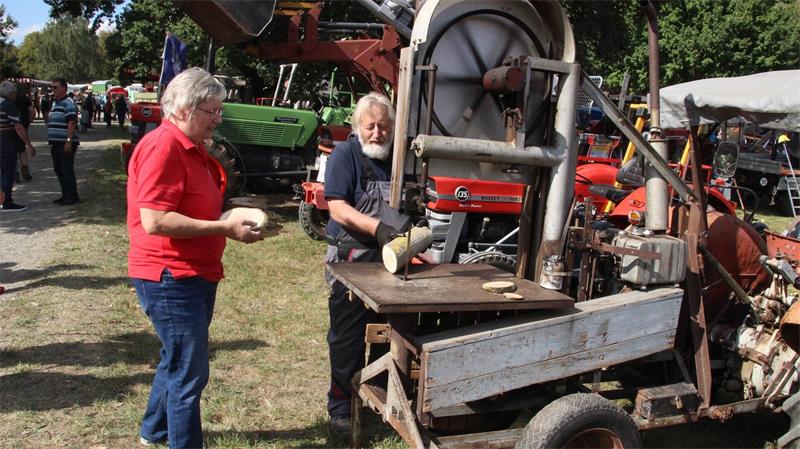 Hoffest auf dem Klostergut in Wöltingerode. Das ist geplant Zwei ältere Personen stehen neben einer historischen landwirtschaftlichen Maschine auf einem Freigelände mit weiteren Fahrzeugen im Hintergrund