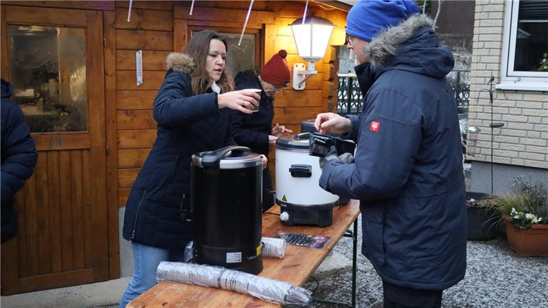 Eine Frau gibt einem Mann eine Tasse.