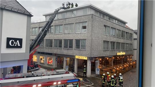 In dem Gebäude gegenüber der C &amp; A-Filiale steigt am Freitagabend Rauch aus dem Dach. Zu einem Brand kommt es aber nicht. Foto: Krause