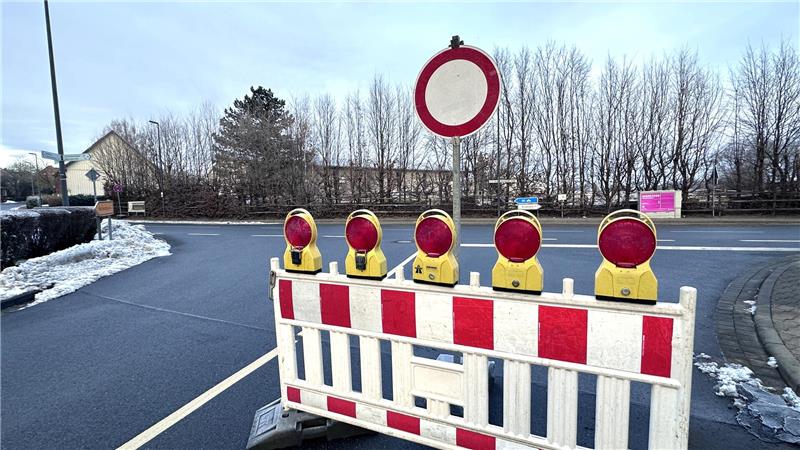 Eine Bauabsperrung steht vor einem Durchfahrt-verboten-Schild auf der Straße.