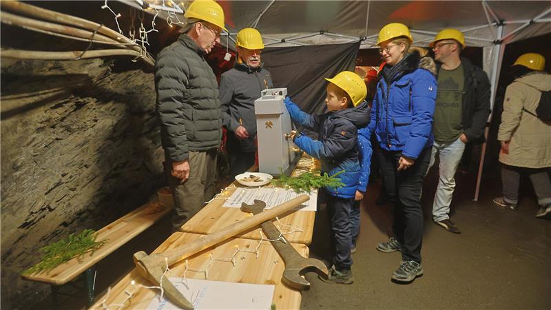Mit gut 10.000 Besuchern ist die Belastungsgrenze erreicht Unter Tage stehen Menschen mit gelben Schutzhelmen um einen Tisch herum, auf dem großes Werkzeuge liegt.