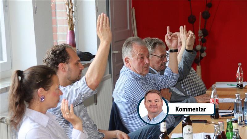 Personen stimmen per Handzeichen ab.