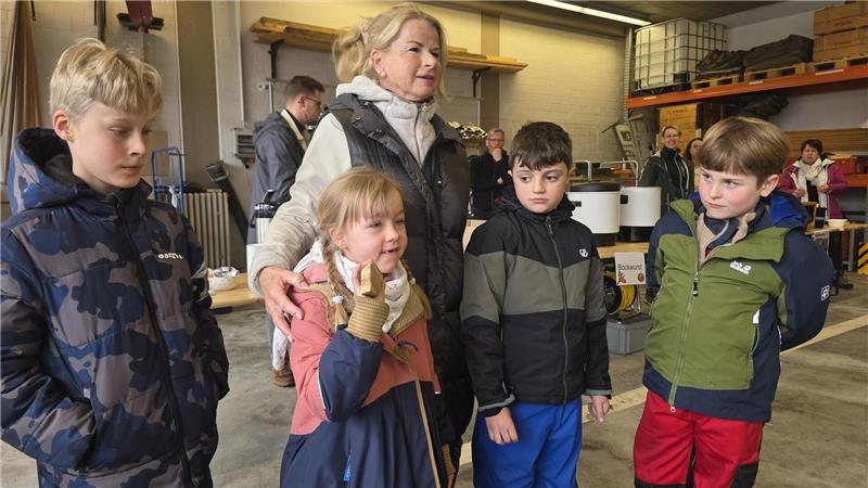 „Müllboss“ in Goslar: Skier, Auspuff und „Drogen“ im Müll entdeckt Gruppe von Kindern und einer erwachsenen Person in einer Halle mit Regalen und technischen Geräten im Hintergrund.