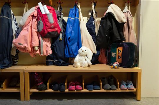 In der Garderobe in einer Kita hängen Kinderjacken.