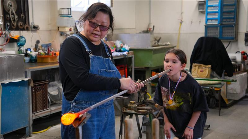 In der Glashütte von Emi Yamamoto versuchen sich die Kinder selbst als Glasmacher.