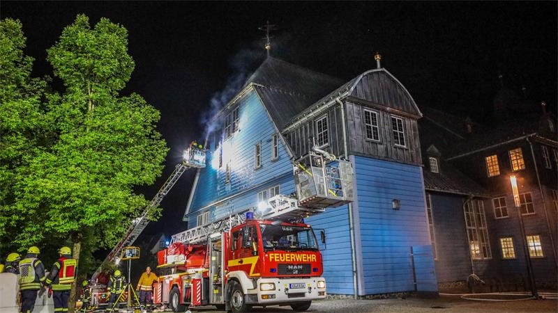 Drehleiterfahrzeuge der Feuerwehr vor der blauen Marktkirche.
