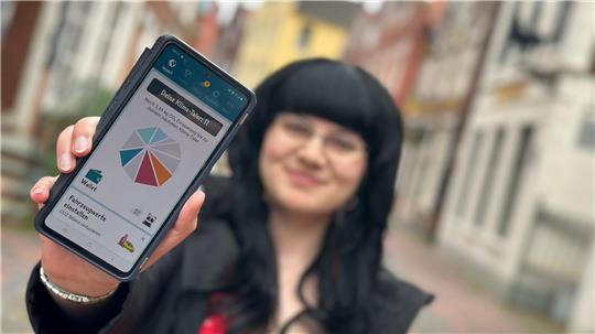In der Stadt Leer ist der Klima-Taler bereits ein voller Erfolg, der allerdings nicht haptisch greifbar ist, sondern per App gesammelt wird, wie die Klima-Managerin Cindy Grätz zeigt.