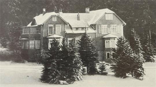 Das Foto zeigt ein Schwarz-Weiß-Winterbild eines Hauses.
