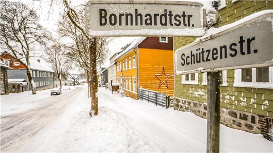 Blick in die verschneite Schützenstraße, im Vordergrund das Straßenschild.