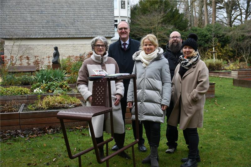 Drei Frauen und zwei Männer stehen hinter einem Lesestuhl.