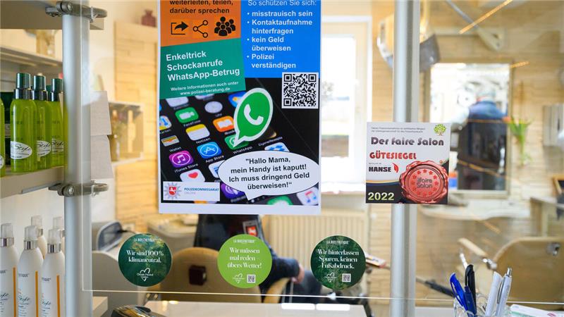 In einem Friseursalon in Lüneburg warnt die Polizei mit einem Plakat über Betrugsmaschen.