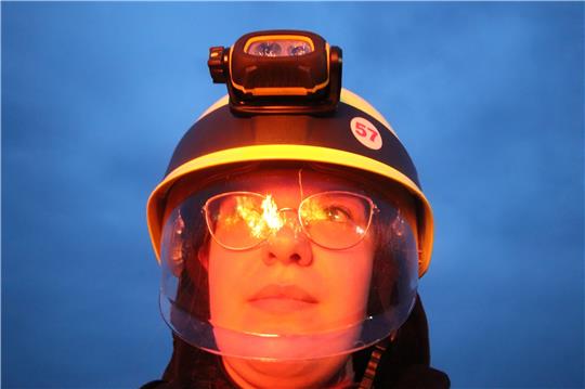 In ihren Augen lodert das Osterfeuer: Im Visier von Ostharingens stellvertretender Ortsbrandmeisterin Anita Kubitschke spiegeln sich die Flammen. Foto: Gereke