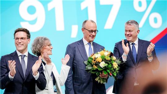 Ina Scharrenbach, Sitzungsleiterin, Gordon Schnieder (r), Spitzenkandidat der CDU in Rheinland-Pfalz, und Manuel Hagel (l), Spitzenkandidat der CDU in Baden-Württemberg, gratulieren Bundeskanzler Friedrich Merz, CDU-Parteivorsitzender, zur Wahl zum Bundesvorsitzenden. 