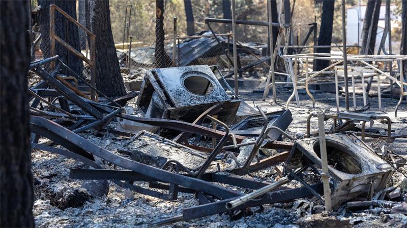 Inferno im Urlaub: Nach einem Waldbrand in Spanien liegen verkohlte Trümmer auf einem Campingplatz.
