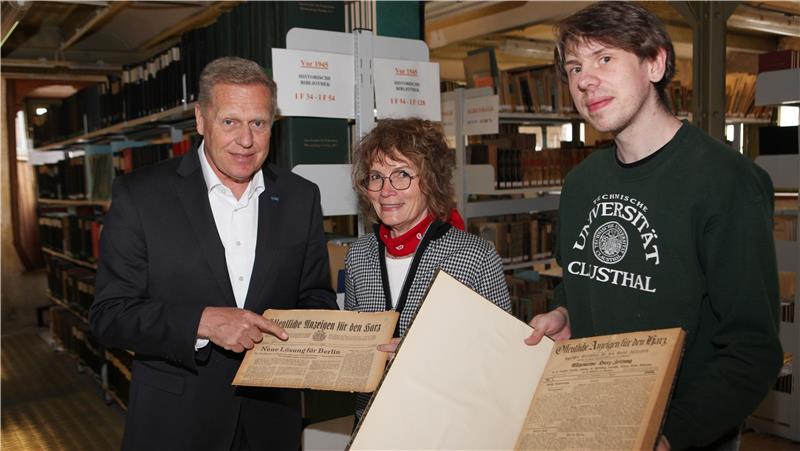 Ingo Küster (l.), Stellvertreter des LBEG-Präsidenten, übergibt in der Bibliothek des Landesbergamts Archivausgaben der Öffentlichen Anzeigen an Andrea Prieskorn von der Universitätsbibliothek und Marco Wedemeyer vom Universitätsarchiv.
