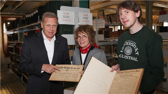 Ingo Küster (l.), Stellvertreter des LBEG-Präsidenten, übergibt in der Bibliothek des Landesbergamts Archivausgaben der Öffentlichen Anzeigen an Andrea Prieskorn von der Universitätsbibliothek und Marco Wedemeyer vom Universitätsarchiv.