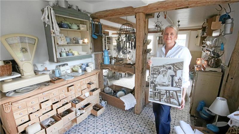 Britta Busse präsentiert in einem alten Laden ein Bild.
