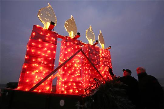 Inspizieren, ob das gigantische Adventsgesteck auf dem Treckeranhänger auch richtig leuchtet (v.li.): Jörg Uhde und Uwe Nass. Foto: Gereke