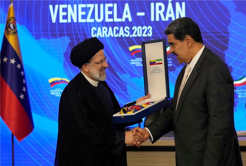 Lateinamerika-Reise: Irans Präsident besucht Venezuela Irans Präsident Ebrahim Raisi (l) gibt Venezuelas Staatsoberhaupt Nicolas Maduro (r) die Hand, als er den Orden "Libertador y Libertadora de Primera Clase" entgegennimmt.