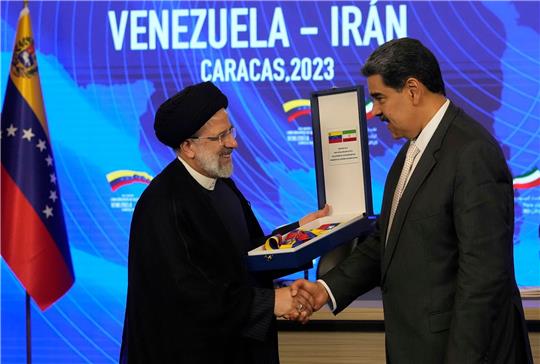 Irans Präsident Ebrahim Raisi (l) gibt Venezuelas Staatsoberhaupt Nicolas Maduro (r) die Hand, als er den Orden "Libertador y Libertadora de Primera Clase" entgegennimmt.