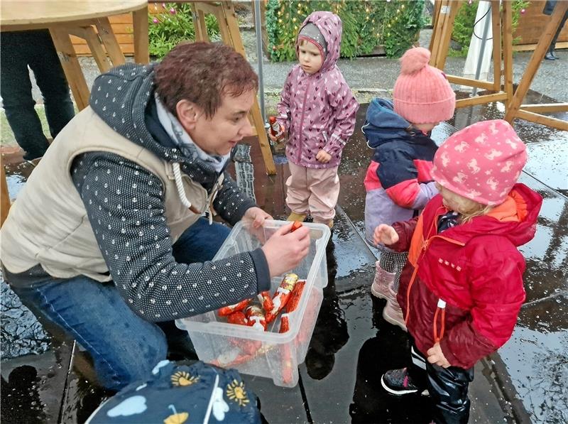 Altenauer Wintermarkt: Eröffnung unter keinem guten Stern Iris Richter aus dem Organisationsteam verteilt Schoko-Weihnachtsmänner an die fleißigen Baumschmücker. Foto: Knoke