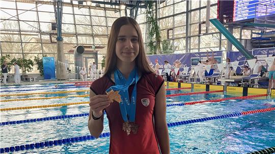 Isabella Janitzki präsentiert im Braunschweiger Sportbad Heidberg ihre Goldmedaille. Darüber hinaus gewinnt sie bei den Landesmeisterschaften zweimal Bronze.