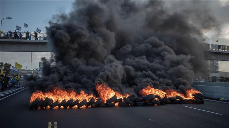 Israelische Demonstranten blockieren mit brennenden Reifen die Hauptverkehrsstraße in Zentralisrael.