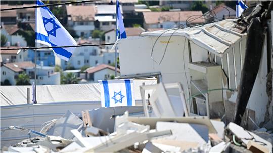Israelische Fahnen an Ort eines iranischen Raketenangriffs in Beit Schemesch. 