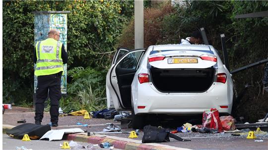 Israelische Rettungskräfte arbeiten neben einem beschädigten Auto nach einem Rammangriff in Raanana. Bei einem Anschlag sind am Montag eine Frau getötet und mehr als ein Dutzend Menschen verletzt worden. Foto: Oren Ziv/dpa