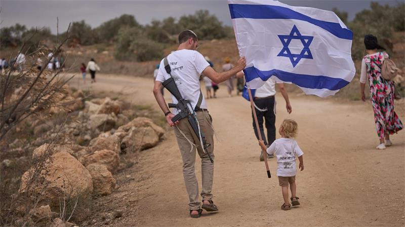 Israelische Siedler gehen auf der Straße zwischen Ganim und Kadim entlang, um die Einweihung des neu errichteten illegalen Außenpostens Kadim im besetzten Westjordanland zu feiern.
