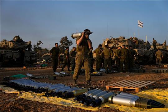 Israelische Soldaten laden nahe der Grenze zum Gazastreifen Granaten auf einen Panzer.