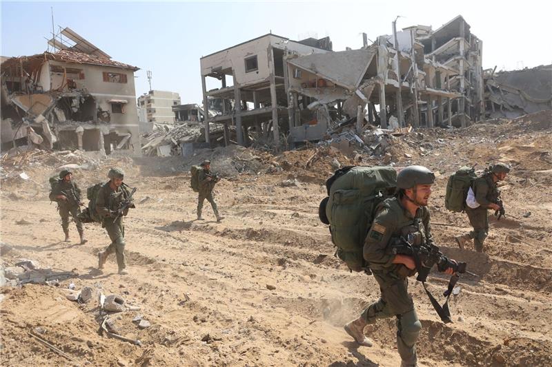 Gaza-Krieg: Neuer Anlauf im Ringen um Feuerpause Israelische Soldaten marschieren während einer Bodenoffensive durch den Ort.