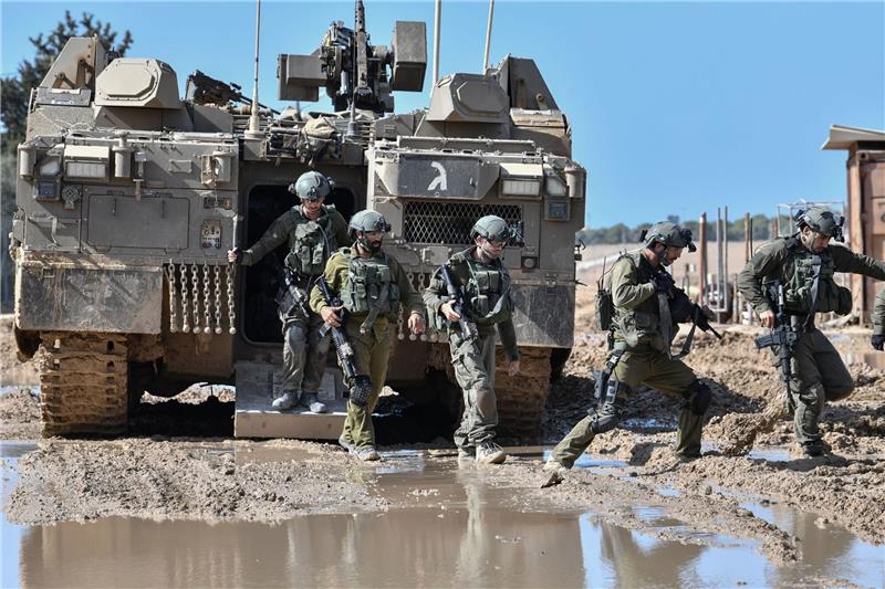 Terrorattacke und Gegenangriff: Was sagt das Völkerrecht? Israelische Soldaten steigen aus einem gepanzerten Fahrzeug nahe der Grenze zwischen Israel und Gaza im Süden Israels.