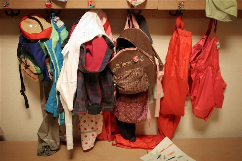 Viele Unternehmen unterstützen Familienplanung Jacken und Rucksäcke von Kindern in der Garderobe einer Betriebskita.