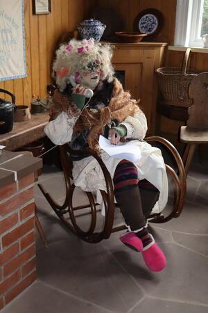 Telefonierende Hexe im Schaukelstuhl. 