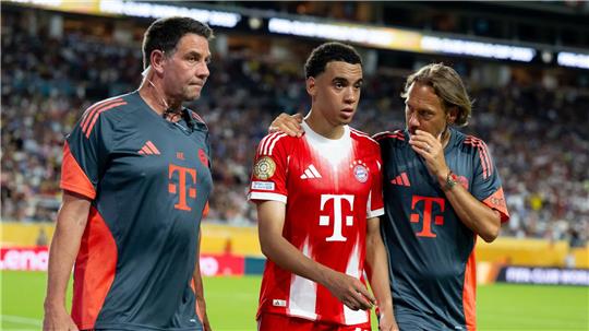Jamal Musiala musste nur 25 Minuten nach seiner Einwechselung angeschlagen vom Platz, begleitet von Teamarzt (r) und Physiotherapeut. 