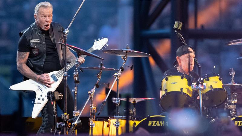 Metallica gibt 2026 drei Konzerte in Deutschland James Hetfield (l), Sänger und Gitarrist, und Lars Ulrich, Schlagzeuger, von der US-Metal-Band Metallica stehen im Münchner Olympiastadion auf der Bühne.