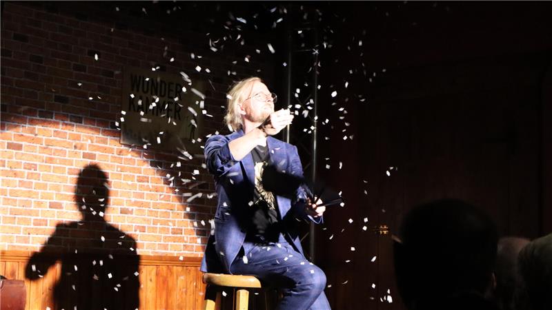 Der Zauberkünstler Jan Logemann im Konfettiregen auf der Bühne. 