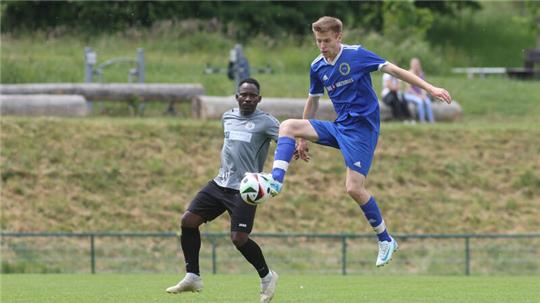 Jan-Philipp Leiber von der TSG Bad Harzburg II nimmt den Ball im Sprung mit, da ist Zidane Imele Zangue von der SVG Oberharz nur Zuschauer.