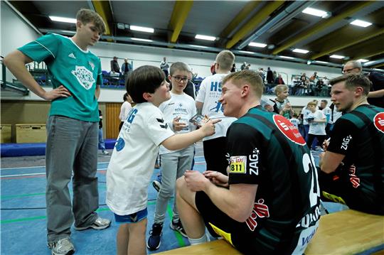 Jannik Beinsen (l.) wartet geduldig, bis die Handball-Profis die Autogrammwünsche der Kinder erfüllen, bevor er an der Reihe ist.  Foto: Epping
