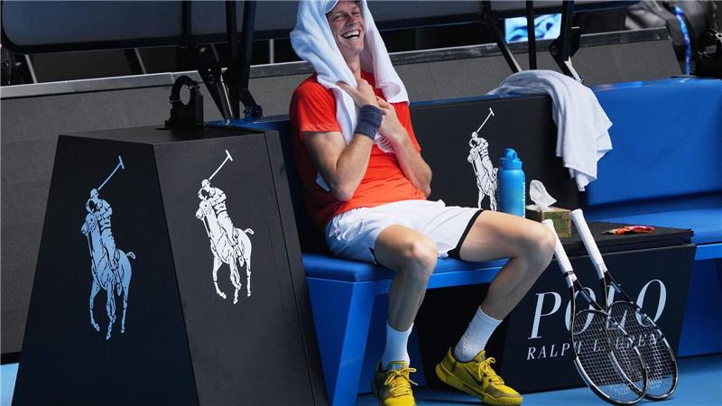 Jannik Sinner lacht während einer Trainingspause.