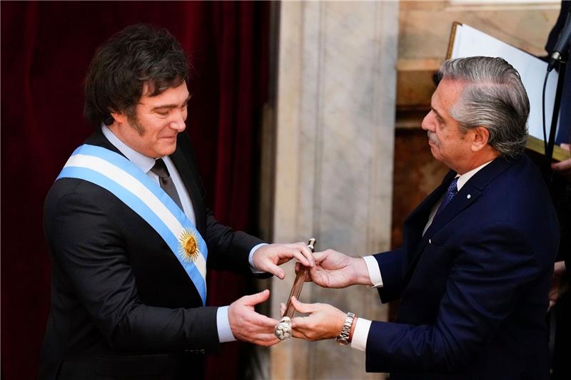 Ultraliberaler Milei als Präsident Argentiniens vereidigt Javier Milei (l) erhält den Präsidentenstock von seinem Amtsvorgänger Alberto Fernandez.