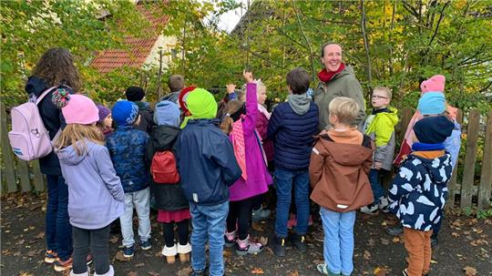 Jeannette Lex sucht mit den Zweitklässlern nach Fledermausquartieren auf dem Schulhof.