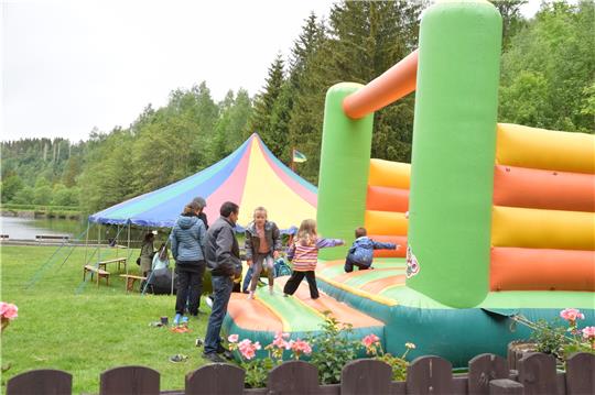 Jede regenfreie Minute nutzen die kleinen Besucher, um beim Kinderfest in Altenau die Hüpfburg zu erobern. Am Waldschwimmbad wird unterm Zirkuszelt auch Dosenwerfen angeboten (kleines Foto).  Fotos: Neumann
