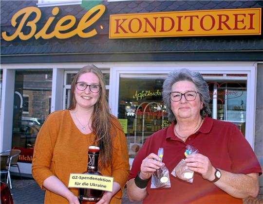 Jennifer und Petra Biel (von links) nehmen mit dem Verkauf von Ukraine-Talern, Amerikanern und Friedenstauben Geld ein, das der GZ-Aktion zugute kommt.  Foto: Knoke