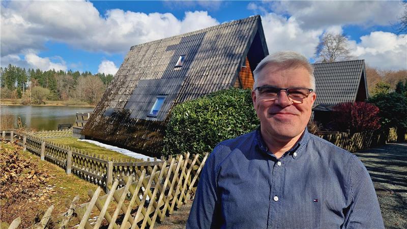 Jens Lutz steht im Ferienpark vor seinen Nurdach-Häusern.
