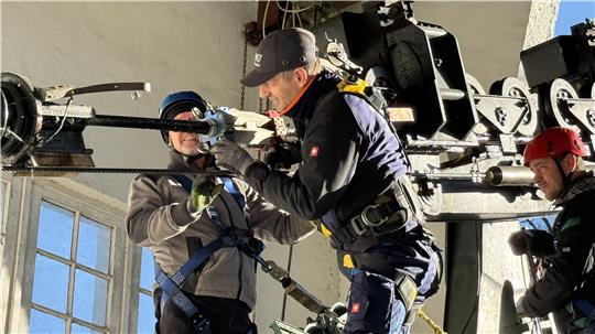 Jens Schumann vom Tüv-Thüringen bringt ein Messgerät am Tragseil an. 
