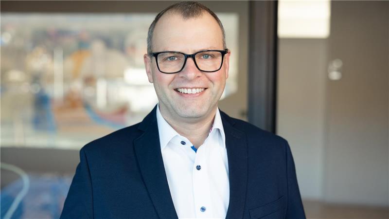 Das Foto zeigt Jens Steinhoff mit dunkler Brille, weißem Hemd und blauem Sakko.