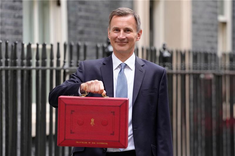 Jeremy Hunt, Finanzminister von Großbritannien, zeigt vor 11 Downing Street seinen roten Aktenkoffer, bevor er seinen Haushaltsplan im Parlament vorstellt.