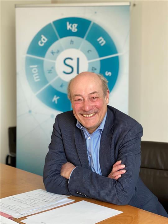 Joachim Ullrich vor einer symbolischen Darstellung des Internationalen Einheitensystems SI. Die Basis bilden sieben Einheiten: der Meter, das Kilogramm, die Sekunde, das Ampere (verdeckt), das Kelvin, das Mol und die Candela. Das SI erfuhr eine grundlegende Auffrischung: Seit dem Weltmetrologietag 2019 werden diese Einheiten durch sieben Naturkonstanten wie etwa die Lichtgeschwindigkeit, die Elementarladung oder das Planck´sche Wirkungsquantum bestimmt - eine universelle Sprache in der Welt des Messens. Foto: Henning Noske